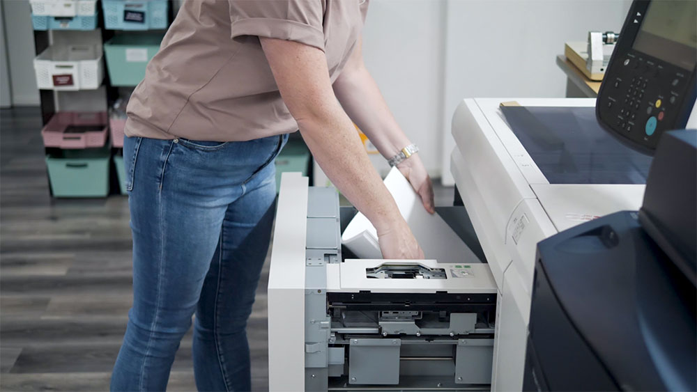 Person replacing paper in a printer
