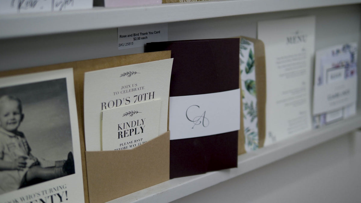 Collection of invitations and stationery items on a shelf