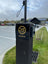 Speed limit sign with a logo and '10 KM/H' text on a pole in an outdoor setting.